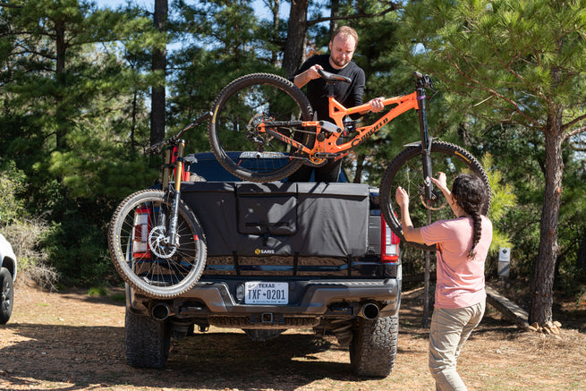 Saris Tailgate Pad with man and woman unloading bikes