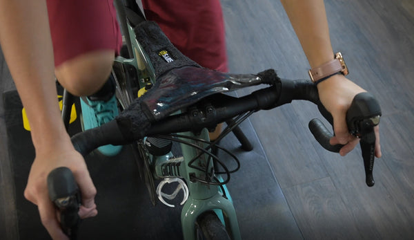 Saris Sweat Guard draped over bike frame on trainer — showing full-frame sweat coverage