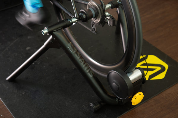 Cyclist on the Saris MAG Plus Trainer — garage setup with bike computer