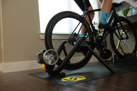 Saris Fluid 2 Smart Trainer in use — rider mid-interval effort, sweat flying