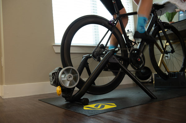 Saris Fluid 2 Smart Trainer in use — rider mid-interval effort, sweat flying
