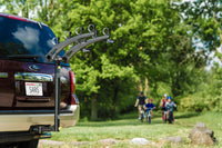 Family loading four bikes onto the Saris Bones 4-Bike Hitch Rack before a ride