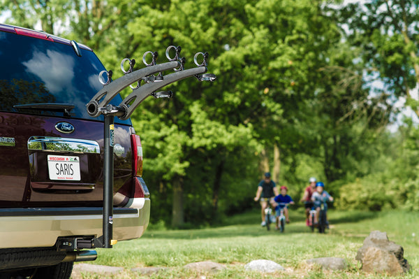 Family loading four bikes onto the Saris Bones 4-Bike Hitch Rack before a ride