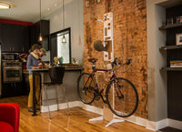 Couple storing bikes with the Saris Hottie Floor Stand in a home garage