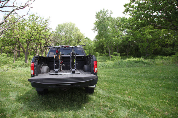 Mountain bike with thru-axle secured in Saris Traps fork-mount carrier — truck bed
