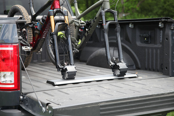 Two mountain bikes loaded in Saris Traps carriers in truck bed — headed to trail