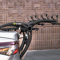 Family loading three bikes onto the Saris Bones 3-Bike Trunk Rack before a weekend ride
