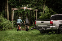 Cyclist loading a road bike onto the Saris SuperClamp G3 2-Bike Hitch Rack
