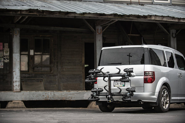 Saris SuperClamp G3 4-Bike Hitch Rack — cable lock securing all four bikes